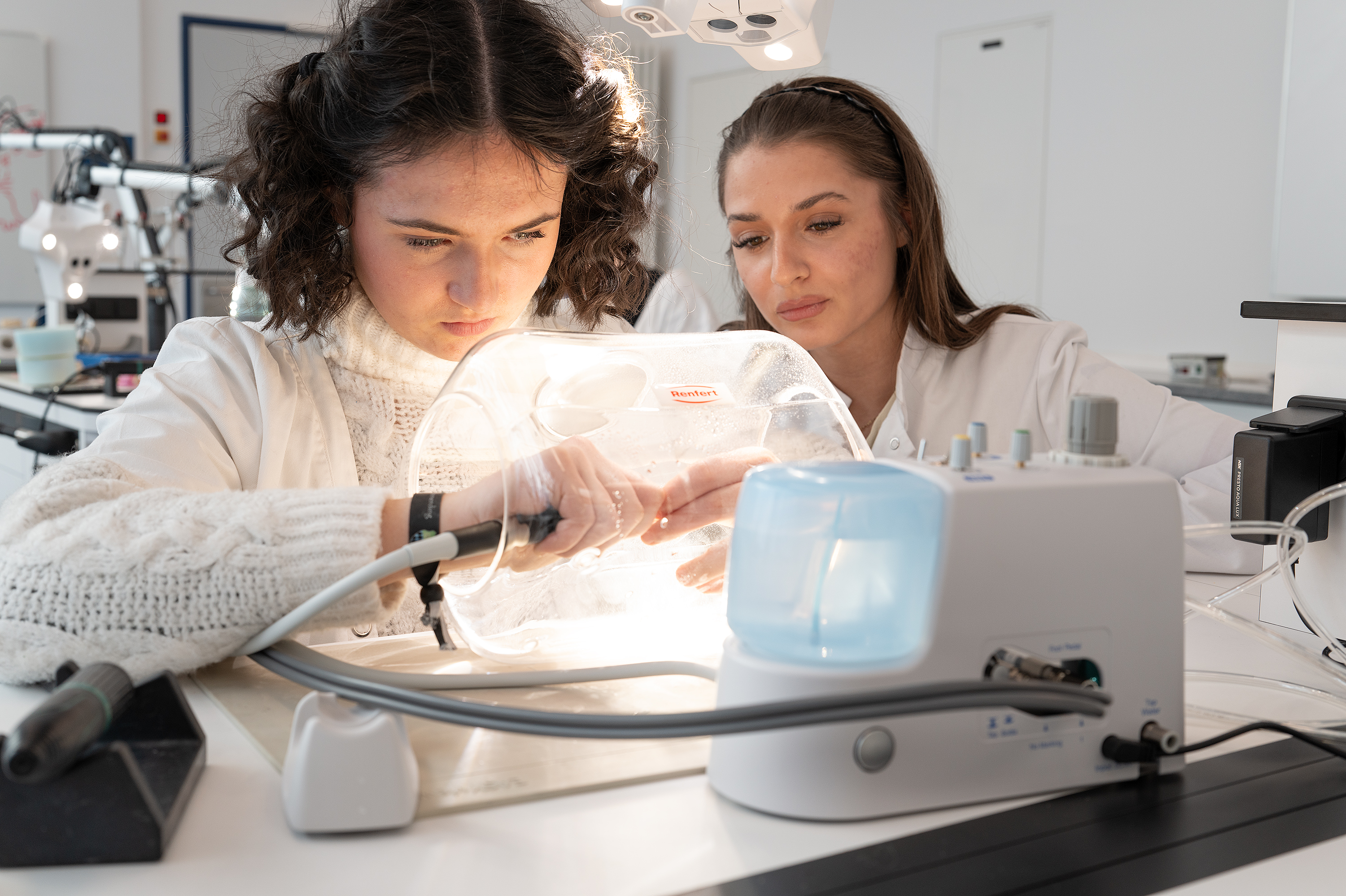 Nahaufnahme eines Zahntechnikers bei der präzisen Arbeit an einem Zahnersatz.